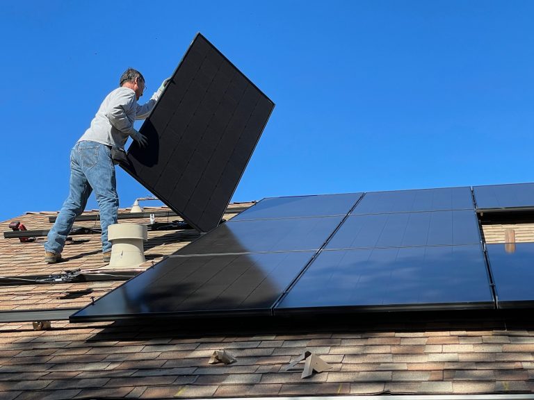 Man Installing Solar Panels On Roof