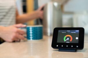 woman holding mug on bench with smart meter in foreground
