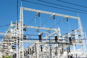 image of white transmission lines and power grids against blue sky