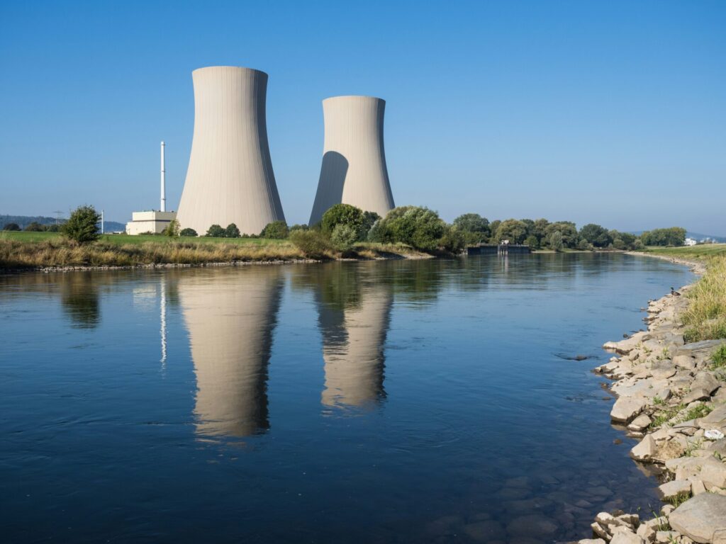 a body of water with two cooling towers in the background representing the nuclear rab levy
