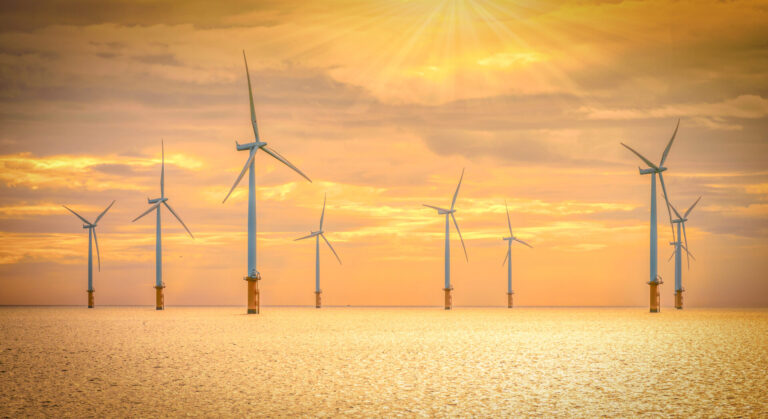 Offshore Wind Turbine in a Windfarm under construction in the North Sea at sunset