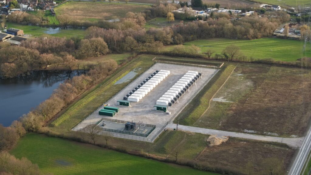 Aerial drone view of a high-capacity battery energy storage system (BESS) facility, showcasing modular grid-scale storage units in the UK.